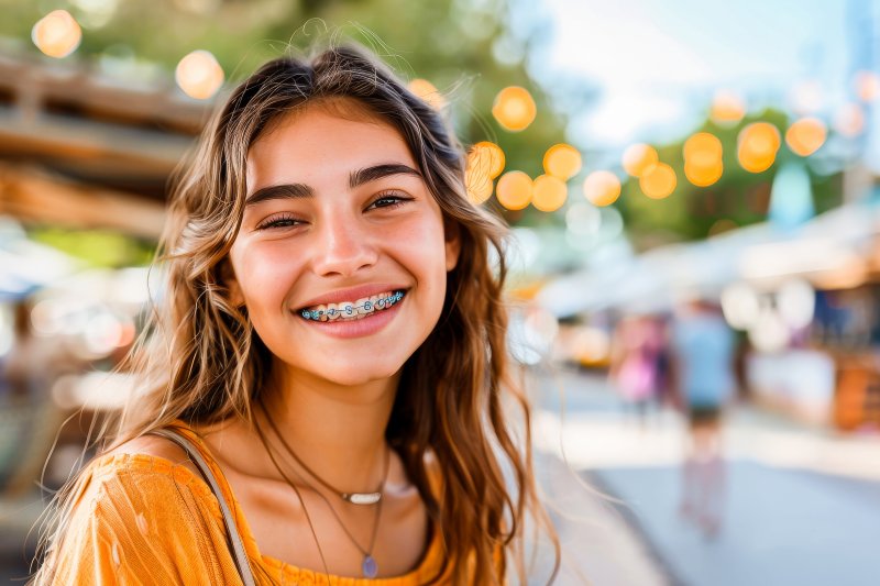 a girl with braces smiling while outside